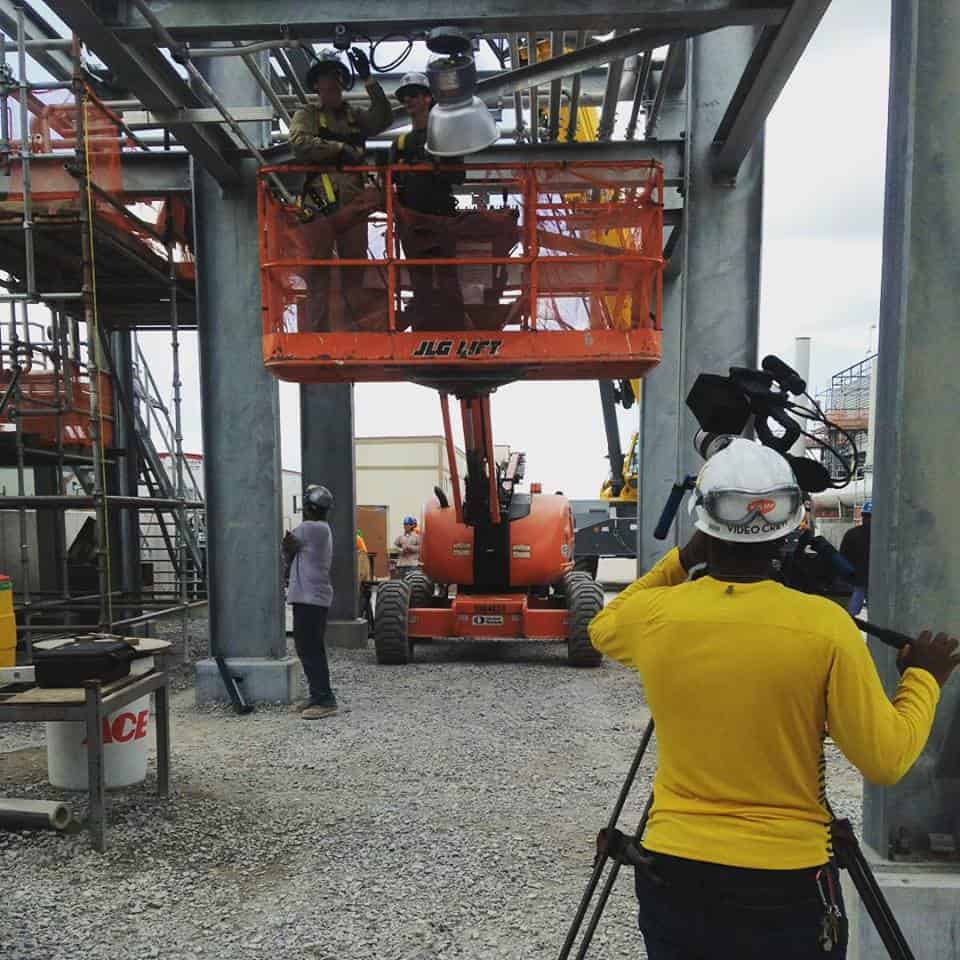 A cameraman films a safety training video on a construction site