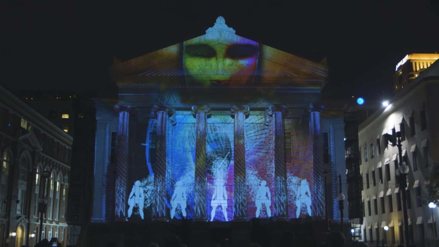 Colorful glow in the dark animation projected on Corinthian style old building at night in city