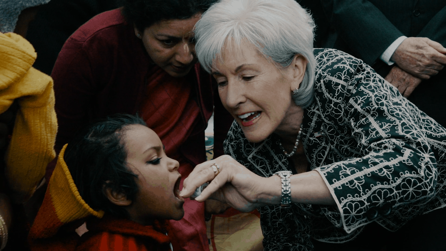A business woman gives medicine to a child in need