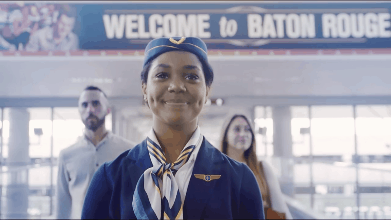A flight attendant guides a couple through the Baton Rouge airport