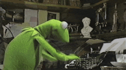 Kermit the frog types on a typewriter 