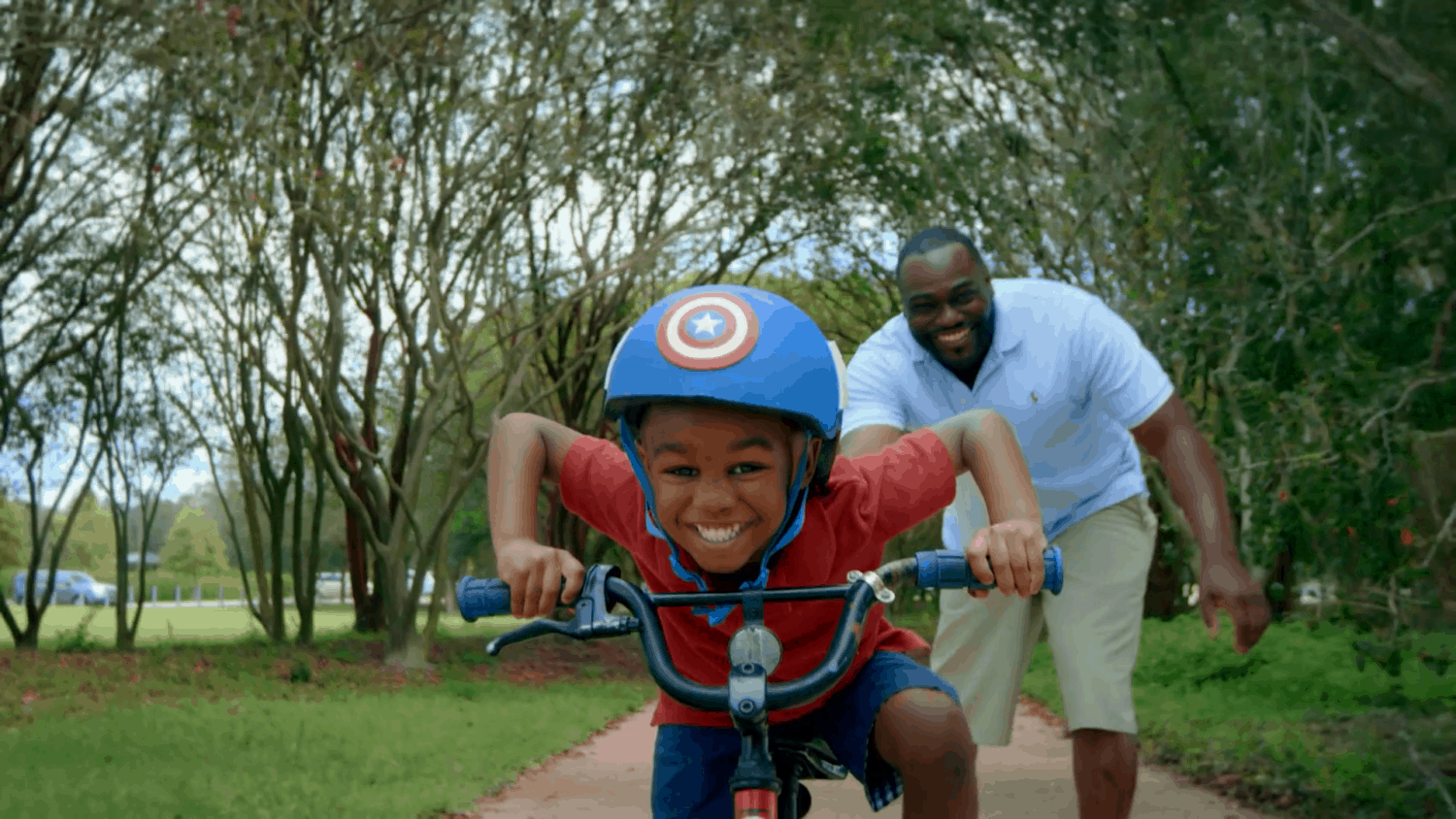 AETNA healthcare member teaches his son to ride a bike