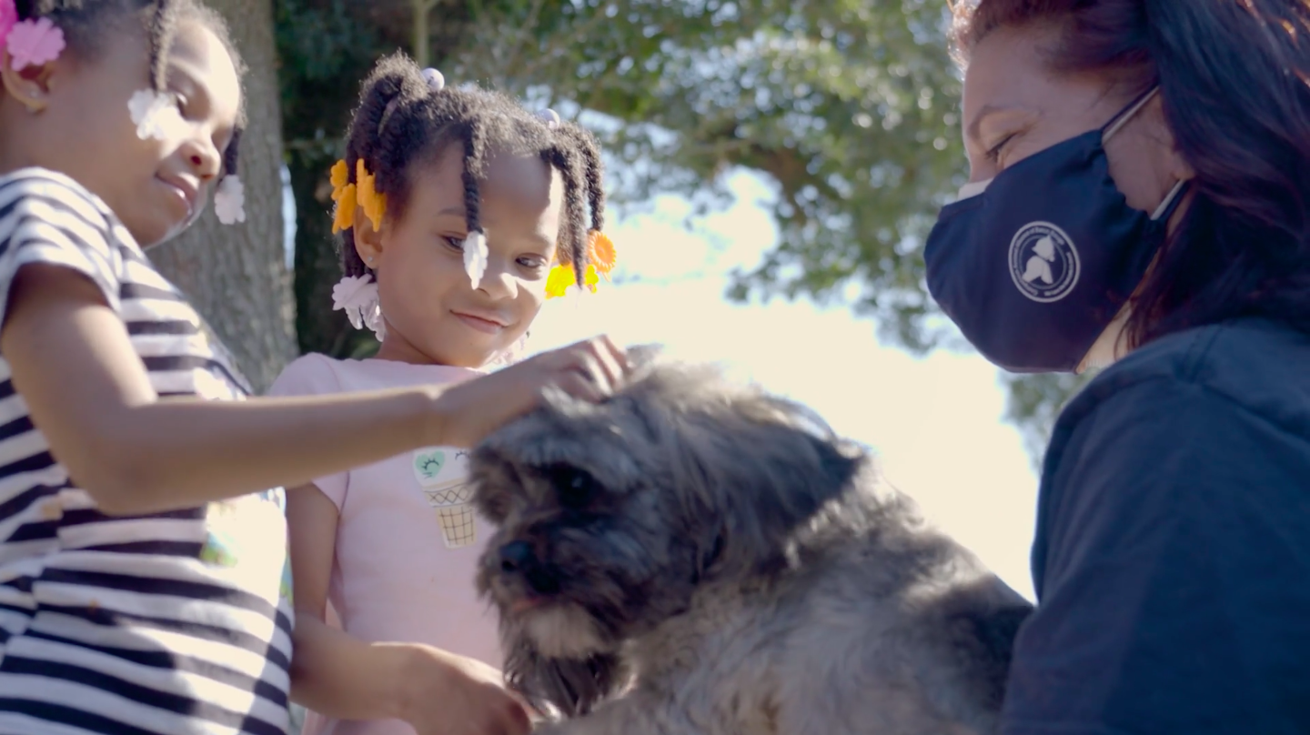 African American girls pet a dog from Companion Animal Alliance